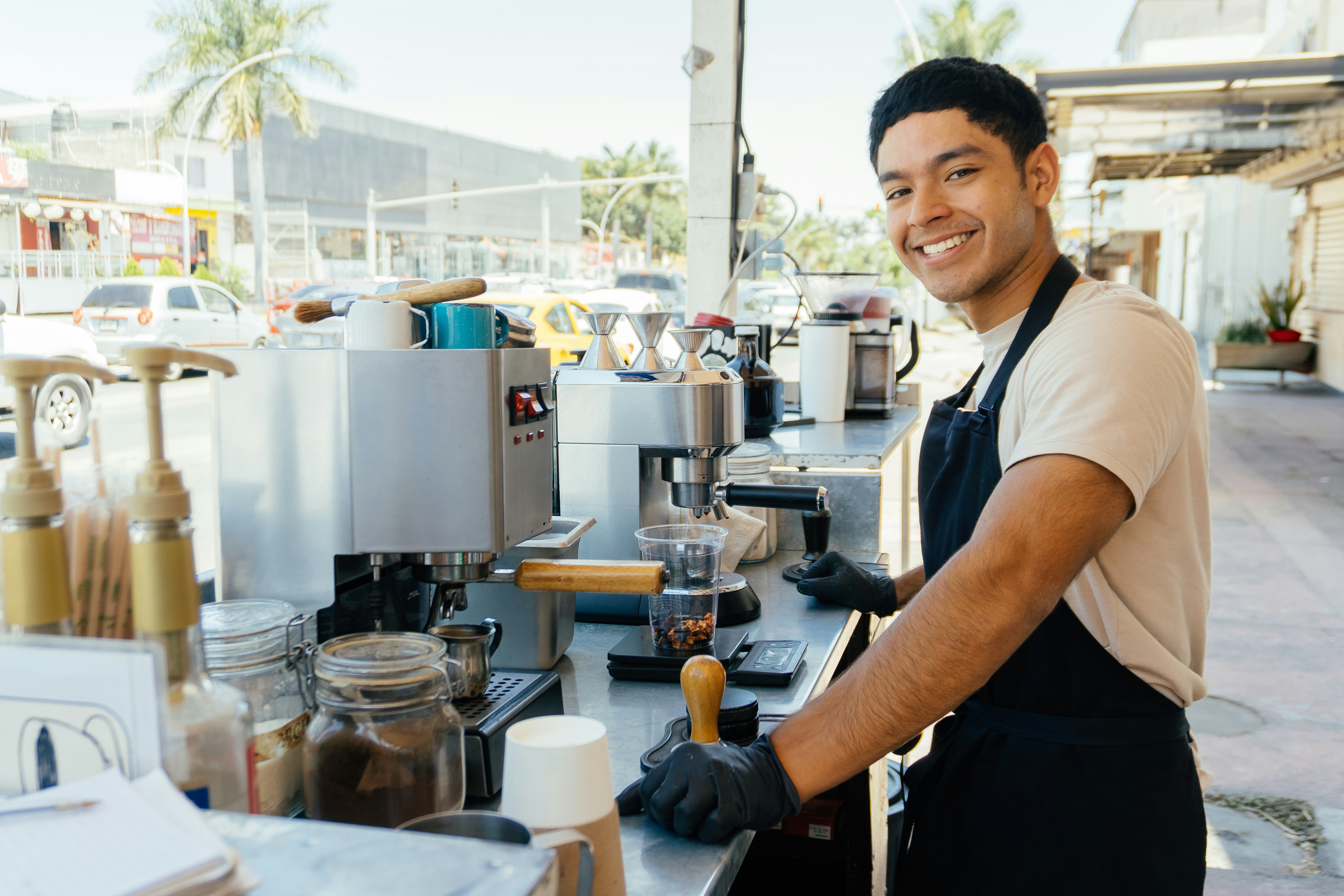 Small business owner preparing coffee behind the counter of his espresso cart